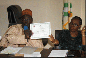 L-R; The Acting Director of Certification, Alhaji Aliu Daura and the Director of Press, Mrs Abosede Aderibigbe holding sample of the new NYSC certificate