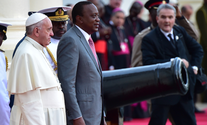 Pope Francis (L) and Kenyan president Uhuru Kenyatta (2nd L) stand in line during a welcome ceremony for Pope's visit at the State House of Nairobi on November 25, 2015. Pope Francis said the world was facing a "grave environmental crisis" as he arrived in Kenya on Wednesday on a landmark Africa trip just days before a crucial UN summit aimed at curbing climate change. He also warned of the need to tackle poverty as a key driver of conflict and violence as he kicked off a landmark Africa trip fraught with security concerns and urged Kenya's leaders to work with "transparency" to ensure a fair distribution of national resources as criticism grows over runaway graft in this east African country. AFP PHOTO