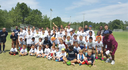 Kids that attended the summer soccer camp at USC with the coaches. Standing right is Ofoje.