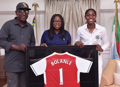 Wife of Lagos State Governor, Mrs. Bolanle Ambode (middle), being presented with an Arsenal Football Club jersey by Super Falcons and Arsenal Ladies FC star, Azeezat Oshoala (right) during Oshoala's courtesy visit to the Wife of the Governor, at Lagos House, Ikeja, on Friday, August 12, 2016. With them is Senior Special Assistant on Sport to the Governor, Mr. Anthony Adeyinka Adeboye (left).