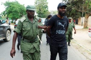 Zambian musician Chama Fumba, known as Pilato, is led away by police after protest.
